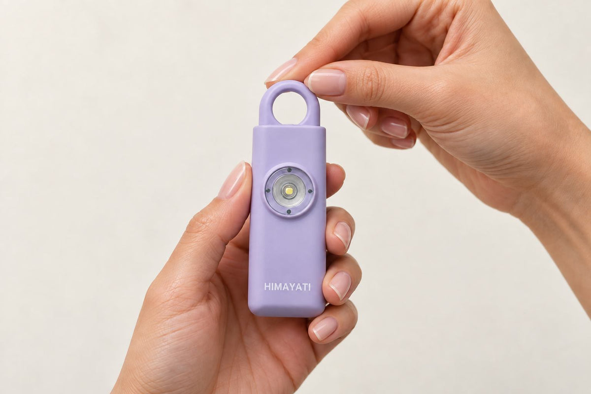 Three friends outdoors, each holding a Himayati personal alarm